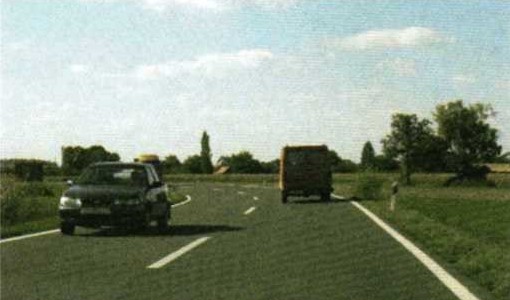 Slika uz pitanje: Kako treba postupiti vozač koji je sustigao vozilo ispred tijekom vožnje u situaciji kao na slici?