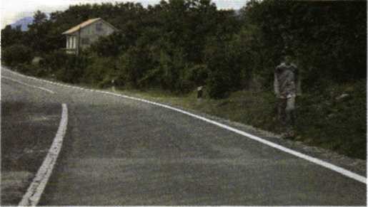 Slika uz pitanje: Vozite cestom i uočite pješaka koji hoda kolnikom u situaciji kao na slici. Kako ćete postupiti?