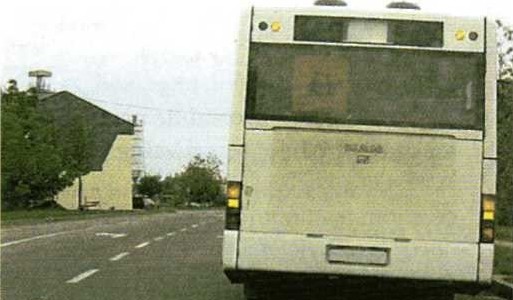 Slika uz pitanje: Vozeći cestom s jednosmjernim prometom približavate se zaustavljenom autobusu u situaciji kao na slici. Kako ćete postupiti?