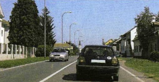 Slika uz pitanje: Sustigli ste vozilo u situaciji kao na slici. Kako se kreće vozač vozila ispred u situaciji kao na slici?