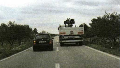 Slika uz pitanje: Pretječe li vozač osobnog automobila teretni automobil, u situaciji kao na slici, propisno?