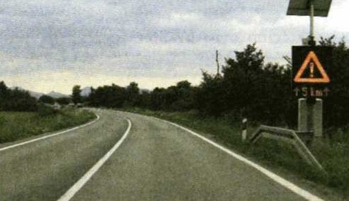 Slika uz pitanje: Zbog čega se bolje uočava prometni znak u situaciji kao na slici?