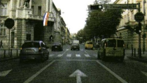 Slika uz pitanje: Vozite u situaciji kao na slici. Kako ćete postupiti u skladu s prometnim znakovima, prometnim svjetlima i oznakama na kolniku?