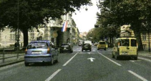 Slika uz pitanje: Pod kojim uvjetima na cesti, u situaciji kao na slici, vozač vozila može voziti trakom koja se ne nalazi uz desni rub kolnika?