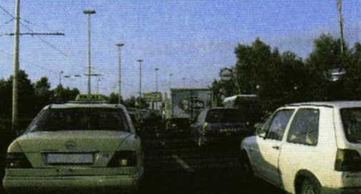 Slika uz pitanje: U gradu vozite u usporednim kolonama vozila, kao u situaciji na slici. Koje su moguće opasnosti?