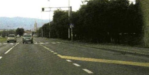 Slika uz pitanje: Što označuje kosa crta na kolniku u situaciji kao na slici?