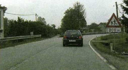 Slika uz pitanje: Vozite cestom u situaciji kao na slici. Kako ćete postupiti?