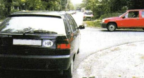 Slika uz pitanje: Kako ćete, kao vozač crnog automobila koji vozi ravno u situaciji kao na slici, postupiti na raskrižju cesta iste važnosti?