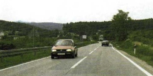 Slika uz pitanje: Sto označuje rubna crta na kolniku u situaciji kao na slici?