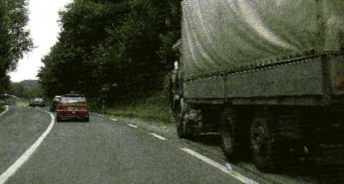 Slika uz pitanje: Što je dužan učiniti vozač vozila koje se kreće brzinom manjom od najveće dopuštene na cesti ili dijelu ceste, pa se zbog toga iza njega stvori kolona vozila?